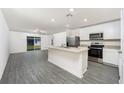 Bright kitchen with stainless steel appliances, center island, and open floor plan at 3736 Bergamot St, Lake Alfred, FL 33850