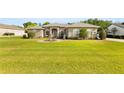 Inviting single-story home with a manicured lawn, stone accents, and a charming circular driveway featuring a central fountain at 5144 Riverlake Dr, Bartow, FL 33830