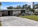 A single-story home with xeriscaping and a covered carport in the front of the home at 2908 Maplewood Ave, Lakeland, FL 33803