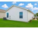 Exterior view of a well maintained yard, showing lawn, potted flowers, and small seating area at 3533 Roanoke St, The Villages, FL 32162