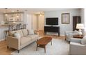 Comfortable living room with wood floors, neutral furniture, and modern decor adjacent to the kitchen at 3533 Roanoke St, The Villages, FL 32162