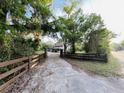 View of the driveway leading to the beautiful two-story home surrounded by lush trees and greenery at 18700 Ravenswood Rd, Altoona, FL 32702
