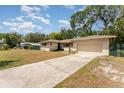 Well-maintained home with a long driveway leading to an attached two-car garage at 933 W Queen St, Lakeland, FL 33803