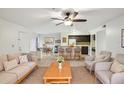 Bright living room showcases an open floor plan with a kitchen island and dining area, plus a ceiling fan and neutral furnishings at 490 N Pin Oak Pl # 112, Longwood, FL 32779