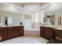 Bright bathroom with a soaking tub, dual sinks, and plenty of vanity storage at 10292 Kristen Park Dr, Orlando, FL 32832
