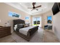 Bedroom features tray ceiling, neutral colors, and access to the backyard at 12329 Sw 140Th Loop, Dunnellon, FL 34432