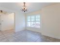 Bright dining room featuring neutral walls, tile flooring, large window, and chandelier at 30505 Island Club Dr., Deer Island, FL 32778