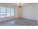 Bright dining room featuring neutral walls, tile flooring, large window, and chandelier at 30505 Island Club Dr., Deer Island, FL 32778