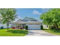 Charming single-story home with a well-manicured lawn and a two-car garage, enhancing curb appeal at 30505 Island Club Dr., Deer Island, FL 32778