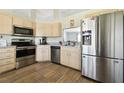 Modern kitchen features stainless steel appliances, light wood cabinetry, and wood-look flooring at 4889 Myrtle View N Dr, Mulberry, FL 33860