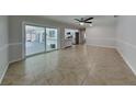 Open living area with tile floors, light gray walls, ceiling fan, and sliding door at 66 Alachua Dr, Winter Haven, FL 33884