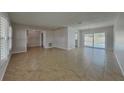 Open-concept living room with tile flooring and sliding glass doors leading to the outdoors at 66 Alachua Dr, Winter Haven, FL 33884