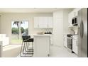 Modern kitchen with stainless steel appliances, island with seating, and sliding glass doors at 1317 Acorn Meadow Loop, Eustis, FL 32726