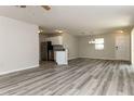 Spacious, freshly painted living room with grey laminate floors, stainless steel appliances, and natural light at 2573 Carrington Ct, The Villages, FL 32162