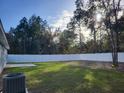 A large backyard with new white vinyl privacy fence and a concrete patio at 13378 Sw 89Th Ter, Ocala, FL 34473
