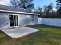 A view of a large, flat concrete patio and partial backyard with new white privacy fence at 13378 Sw 89Th Ter, Ocala, FL 34473