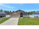 Charming single-story home with a well-manicured lawn, concrete driveway, and an attached two-car garage at 329 W Aster Ct, Poinciana, FL 34759