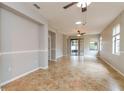 Spacious living room featuring neutral walls, tile flooring, ceiling fans, and natural lighting at 505 Millifiora Ln, Kissimmee, FL 34759