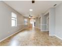 Bright living room with tile floors, a ceiling fan, and large windows with a bright neutral color at 505 Millifiora Ln, Kissimmee, FL 34759