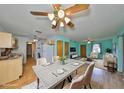 Open-concept living and dining area with laminate flooring, ceiling fans, and abundant natural light at 9210 Lehall W Sq, Lakeland, FL 33810