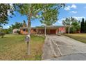 Charming single-story home featuring a carport and well-maintained front yard with mature trees and a mailbox at 4912 Marla Ave, Lakeland, FL 33812