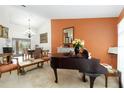 Elegant living room showcasing a piano, dining table, and sliding glass doors to the pool at 4014 Gallagher Loop, Casselberry, FL 32707