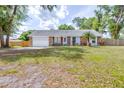 Single-story home with attached garage, brick accents, manicured lawn, and mature landscaping at 7220 Pinehaven Dr, Lakeland, FL 33810
