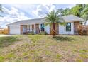 Charming single-story home featuring brick accents, an attached garage, and front yard with a palm tree at 7220 Pinehaven Dr, Lakeland, FL 33810