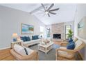 Bright living room featuring a stone fireplace, ceiling fan, and comfortable seating arrangement at 7220 Pinehaven Dr, Lakeland, FL 33810