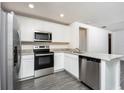Well-equipped kitchen showcasing white cabinets, stainless steel appliances, and a practical island with granite countertops at 3824 Corsican Pl, Lake Alfred, FL 33850