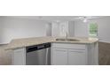 Open-concept kitchen showcases granite countertops, stainless steel dishwasher, and white cabinetry at 481 Danube Dr, Poinciana, FL 34759