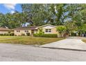 Charming single-story home with a well-manicured lawn and mature trees at 4915 Whiteoak E Dr, Lakeland, FL 33813