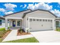 Beautiful single-story home featuring a two-car garage and a landscaped front yard under a bright sky at 3829 Corsican Pl, Lake Alfred, FL 33850