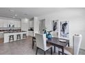 Open-concept dining area with dark wood table, light-colored chairs, and an adjacent kitchen at 611 Terrapin Dr, Debary, FL 32713