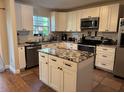 Well-equipped kitchen featuring white cabinets, granite countertops, stainless steel appliances, and an island at 665 Oak Harbour Dr # 115, Altamonte Springs, FL 32701