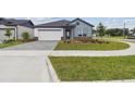 Inviting single-story home features a neatly maintained lawn and a driveway with a gray brick pattern at 5950 Bristle Oak St, Mount Dora, FL 32757