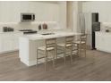 Bright kitchen featuring white cabinets, stainless steel appliances, and an island with barstool seating at 6192 Sw 97Th St, Ocala, FL 34476