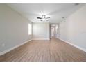 A spacious living room featuring light gray walls, wood floors, and a ceiling fan at 7696 Somersworth Dr, Kissimmee, FL 34747
