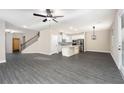 Open-concept living room and kitchen area with gray wood flooring and natural light at 7740 Somersworth Dr, Kissimmee, FL 34747