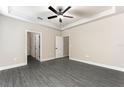 Bright and airy main bedroom featuring tray ceiling, ceiling fan, and en suite bathroom at 7740 Somersworth Dr, Kissimmee, FL 34747