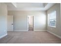 Bright bedroom showcases plush carpeting, neutral walls, and a large window with natural light at 7869 Somersworth Dr, Kissimmee, FL 34747