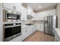 Modern kitchen boasts stainless steel appliances, white cabinetry, and a stylish tile backsplash at 7869 Somersworth Dr, Kissimmee, FL 34747