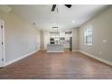 Spacious living room featuring hardwood floors and a view of the open-concept kitchen and island at 7869 Somersworth Dr, Kissimmee, FL 34747