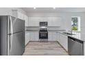 Well-equipped kitchen with stainless steel appliances, white cabinets, and granite countertops at 385 Begonia Ct, Poinciana, FL 34759