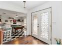 Inviting interior showcasing a game room with a pool table and checkered flooring, accessible through ornate glass doors at 132 Margate Mews, Longwood, FL 32779