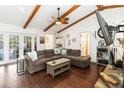 Bright living room with hardwood floors and wood beams, plus a large sectional couch that provides comfortable seating at 132 Margate Mews, Longwood, FL 32779