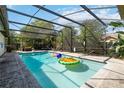 Inviting screened-in pool with clear blue water, complete with colorful inflatable toys and lounge chairs at 132 Margate Mews, Longwood, FL 32779