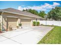 Spacious three-car garage with a large driveway, basketball hoop, and well-maintained landscaping at 2376 Home Again Rd, Apopka, FL 32712