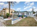 Quaint beach home featuring colorful blue trim, a garden, and a cozy outdoor seating area at 370 Hartford Ave, Daytona Beach, FL 32118