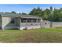Home exterior featuring a green roof, decorative stars, and a well-kept lawn surrounded by lush trees at 4719 Dove Cross Dr, Lakeland, FL 33810